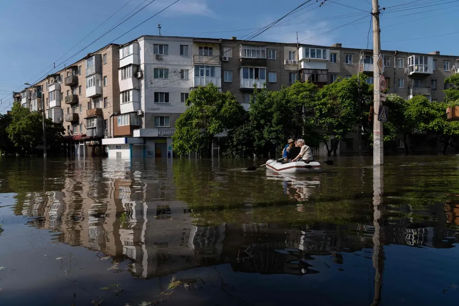 Soldados ucranianos transportam moradores de Kherson em um bote inflável, após destruição de barragem deixar a cidade alagada 