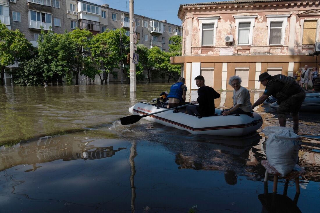 Militares ucranianos transportam um residente local em um barco durante uma evacuação de uma área inundada em Kherson 