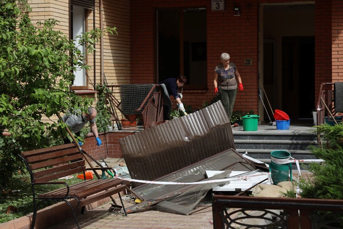 Moradores limpam os escombros de um prédio residencial, danificado após um ataque russo em Odessa