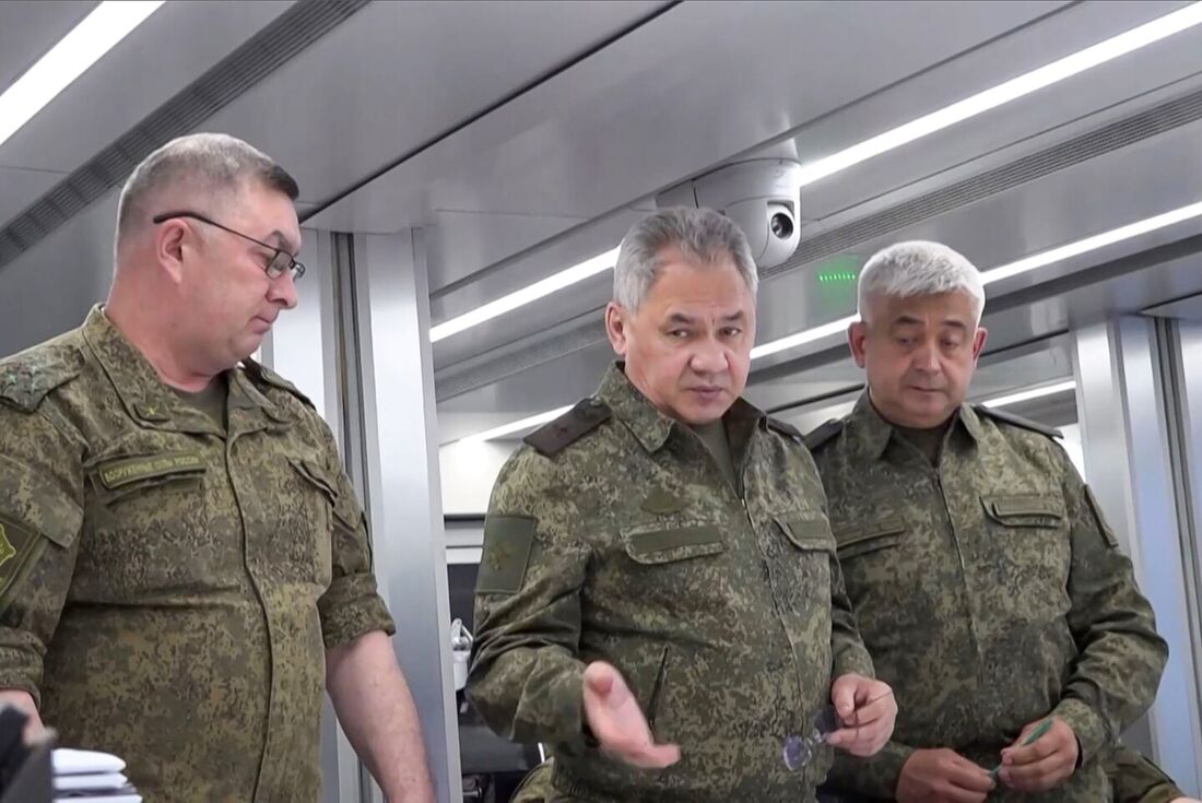 Ministro da Defesa da Rússia, Sergei Shoigu, entre os oficiais enquanto eles olham para um mapa em um local não revelado