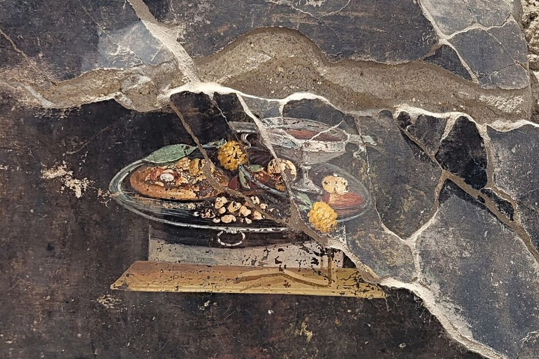 Uma natureza morta, encontrada pelas novas escavações do Regio IX, retratada na parede de um antigo Casa pompeiana que poderia ser um ancestral distante da pizza moderna