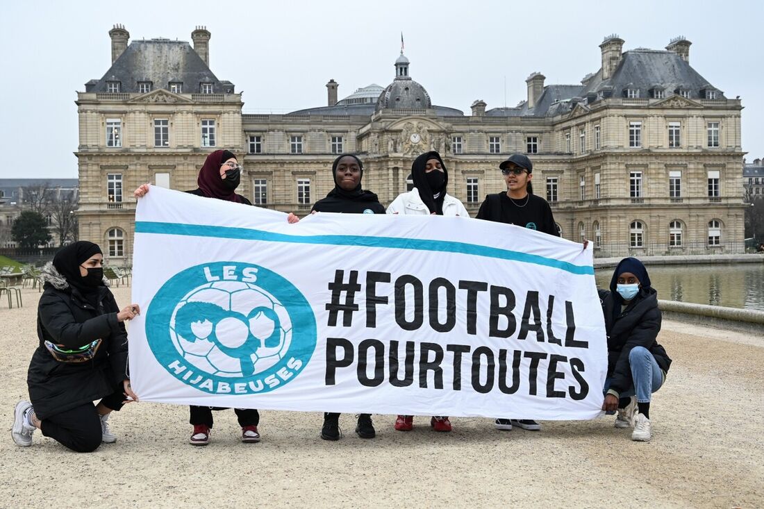  Mulheres que se autodenominam "Hidjabers" posam com uma faixa dizendo em francês "#futebol para todos"
