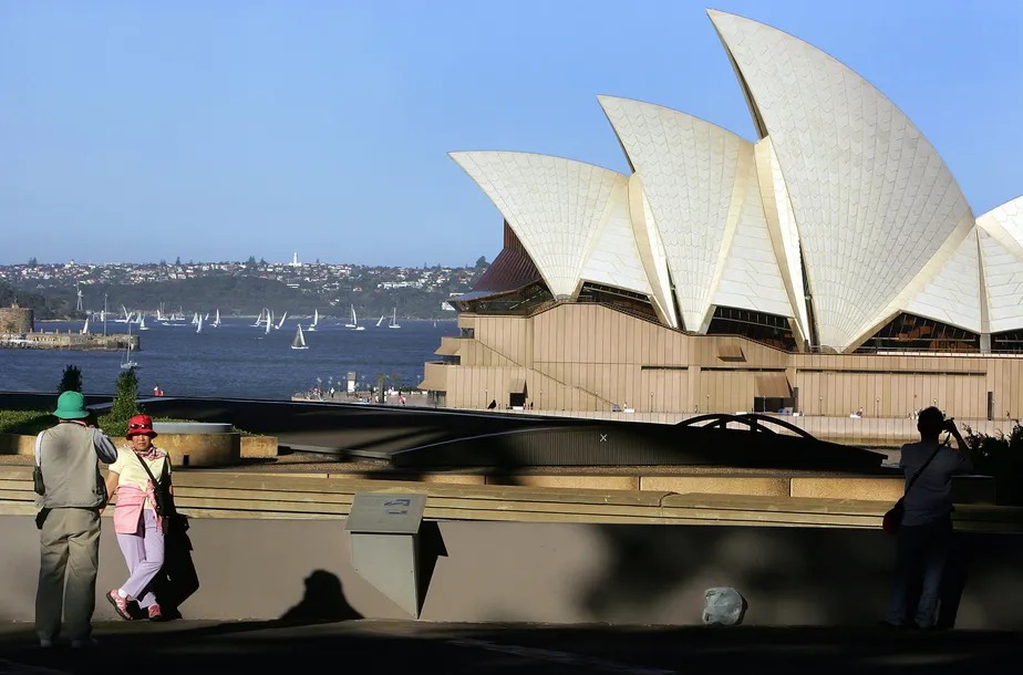 Turistas tiram fotos em frente à Opera House, em Sydney: Austrália é o principal destino dos milionários que emigram 