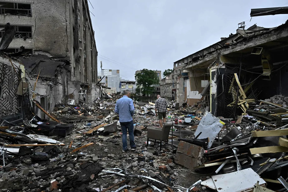 Moradores caminham em escombros de prédio  em Kramatorsk, na Ucrânia.