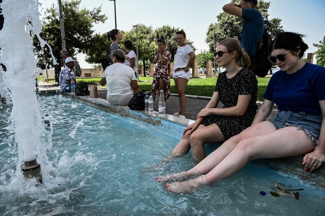 Turistas se refrescam em uma fonte, em Thessaloniki, enquanto a Grécia é atingida por uma onda de calor.