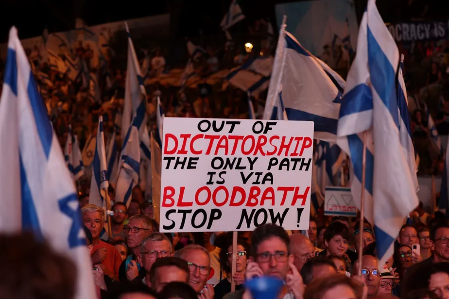 Manifestantes levantam cartazes enquanto marcham em Jerusalém para protestar contra o projeto de reforma judicial do governo 