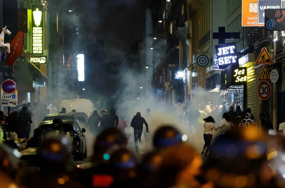 Manifestantes correm enquanto policiais franceses usam gás lacrimogêneo, em Paris 