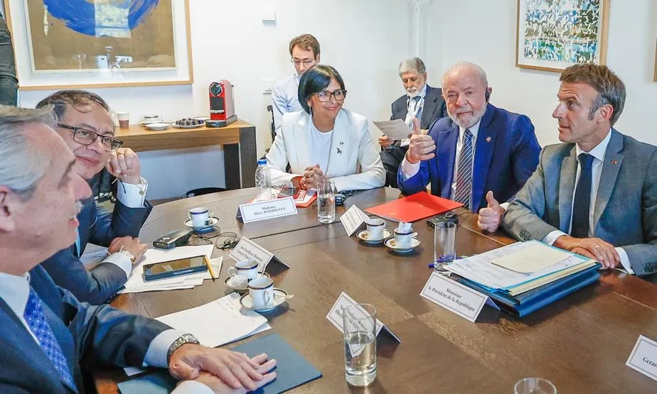Lula, ao lado do presidente francês, Emmanuel Macron, e da vice-presidente venezuelana, Delcy Rodríguez, participa de reunião entre governo e oposição da Venezuela 