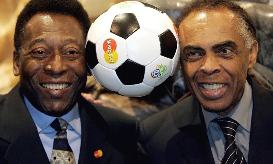 Na foto, Pelé (esq.) e Gilberto Gil (dir.) dividem bola de futebol com a cabeça