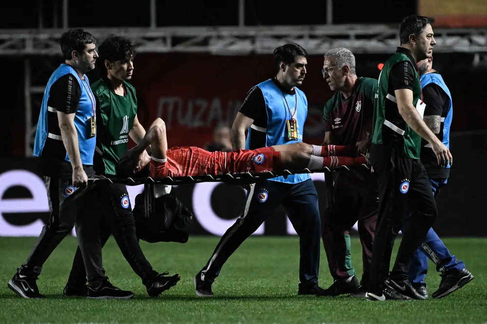 Luciano Sanchez, do Argentino Juniors, sai de maca do jogo contra o Fluminense 