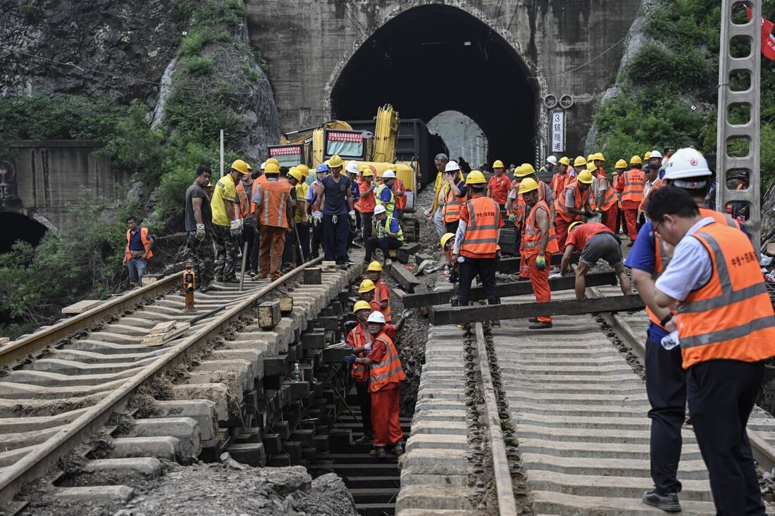 Trabalhadores consertam a ferrovia após a inundação em um vilarejo após fortes chuvas em Pequim 