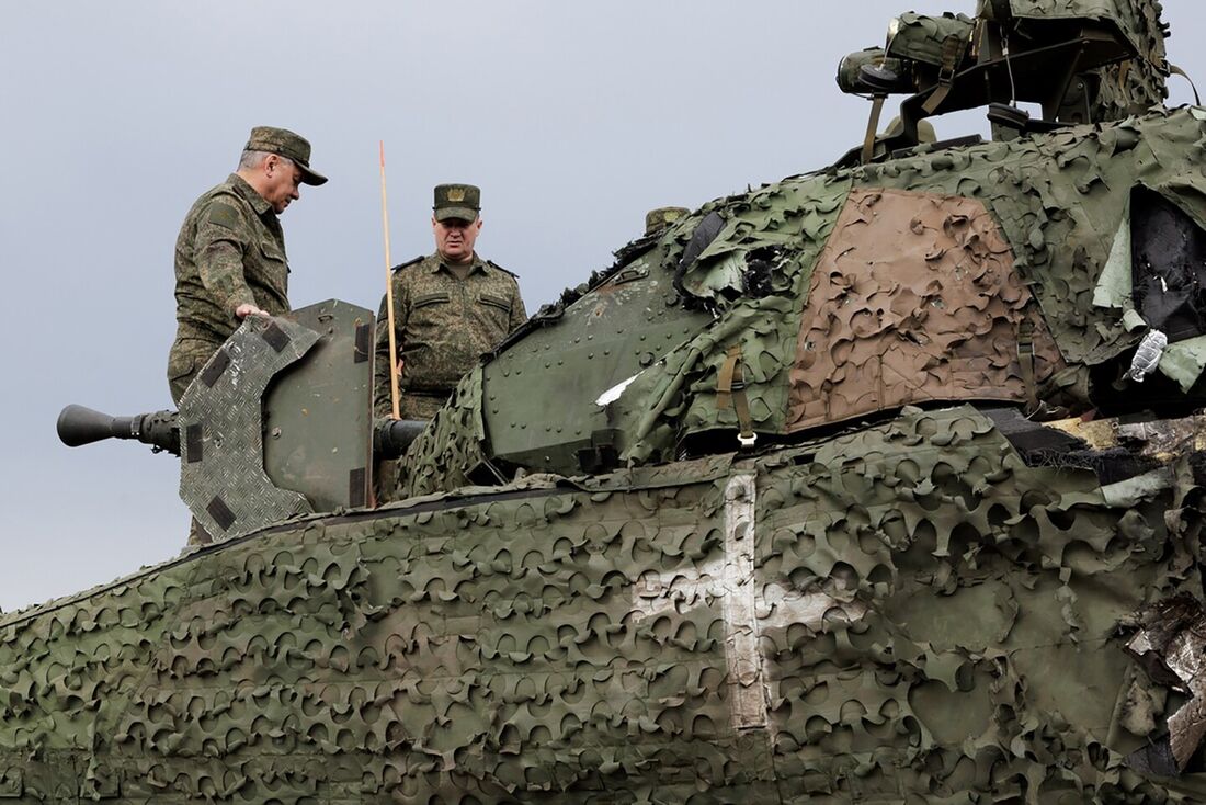 Ministro da Defesa da Rússia, Sergei Shoigu (E), entrando em um veículo blindado sueco CV90