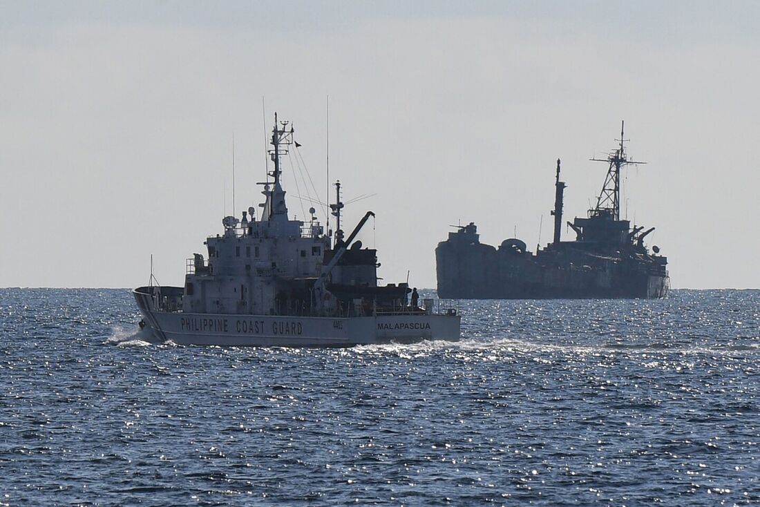 Navio da guarda costeira filipina BRP Malapascua patrulhando perto do navio da marinha encalhado BRP Sierra Madre