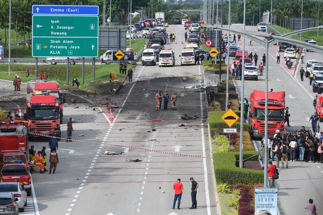 Bombeiros e resgate inspecionam o local do acidente de um avião na Malásia