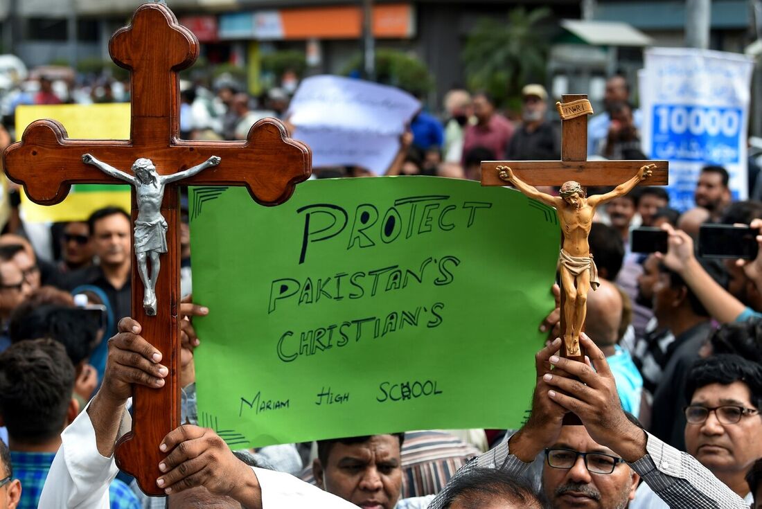 Ativistas da sociedade civil e membros da comunidade cristã seguram cartazes e cruzes enquanto participam de um protesto para condenar os ataques a igrejas no Paquistão, em Karachi.