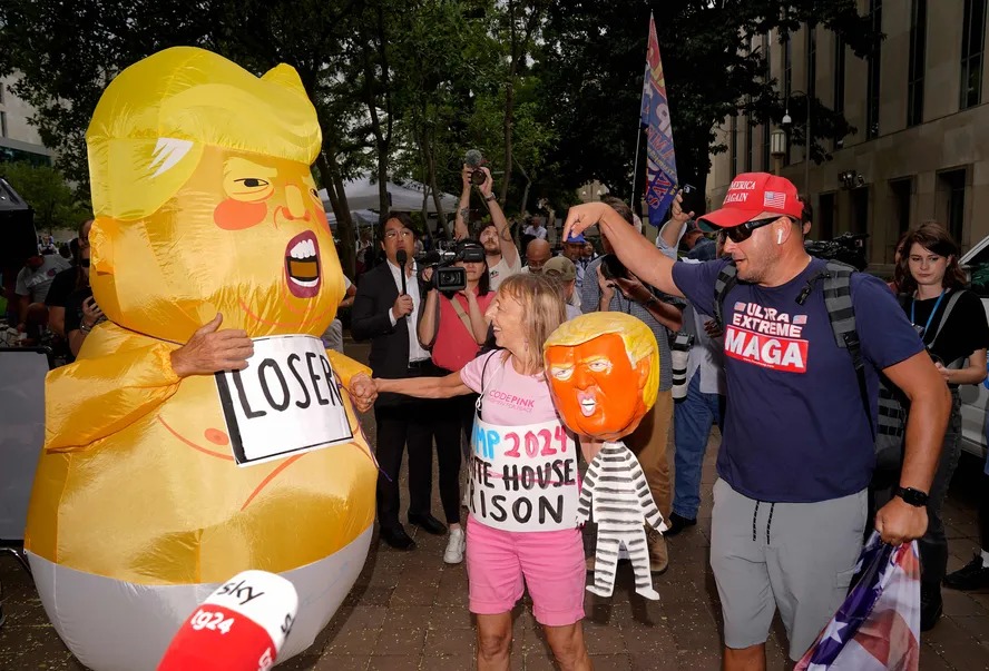 Pessoa fantasiada de Donald Trump vestido de bebê caminha em frente ao Tribunal E. Barrett Prettyman, em Washington, onde o ex-presidente ouviu acusações criminais na quinta-feira