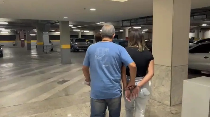 A bombeira civil é acompanhada por um policial logo após ser presa no shopping