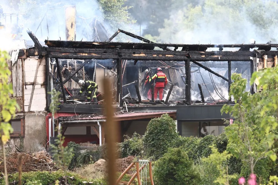 Bombeiros inspecionam um prédio queimado após um incêndio em uma casa para pessoas com deficiência em Wintzenheim