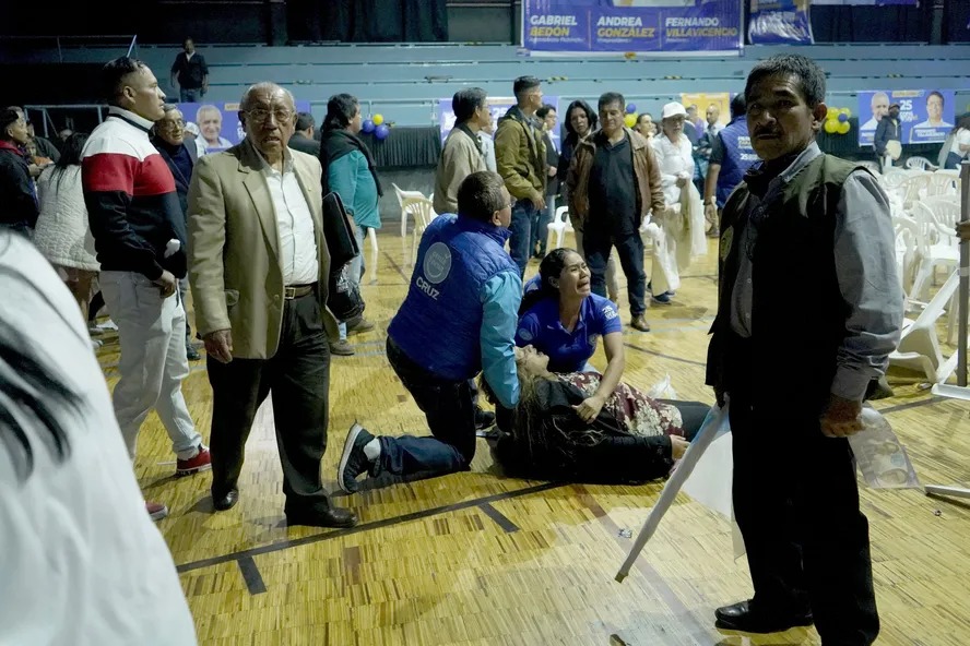 Mulher recebe socorro após ser ferida durante atentado que matou o candidato equatoriano Fernando Villavicencio