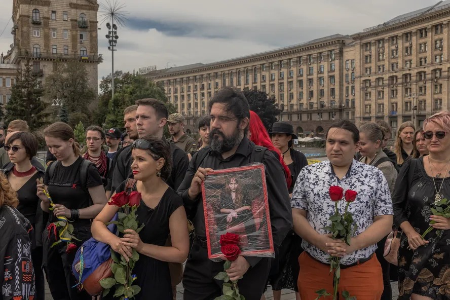 Pessoas seguram flores e um retrato de Daria Filipieva, uma médica de combate do exército ucraniano que foi morta na região de Donetsk