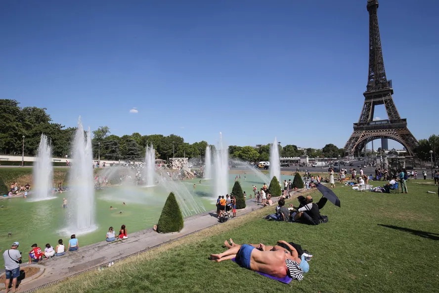 Pessoas se refrescam na fonte do Trocadero, próximo à Torre Eiffel 