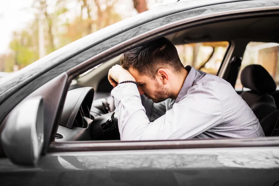 Homem cansado dirige carro 