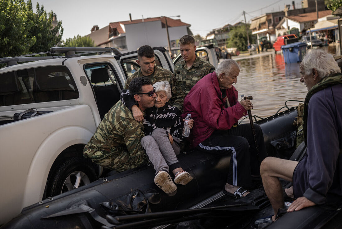 Voluntários resgatam uma mulher idosa na vila inundada de Palamas, no centro da Grécia