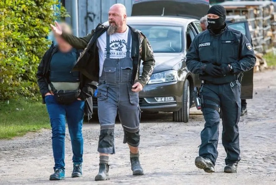 Sven Krueger, um dos neonazistas mais famosos da Alemanha e membro dos Hammerskins, segundo escoltado por policiais após proibição do grupo no país