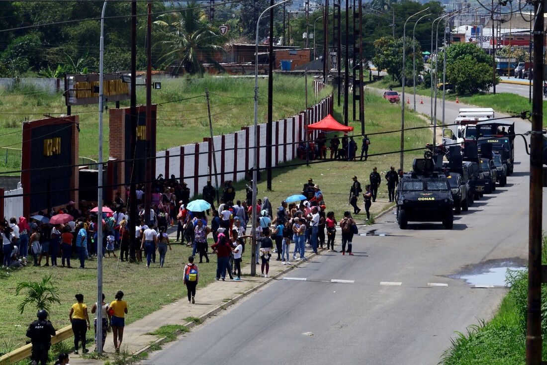 Imagens de presos sentados e algemados no pátio central da prisão, após serem retiradas de suas celas por militares e policiais