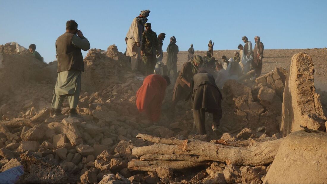 Residentes afegãos limpam os destroços de uma casa danificada após o terremoto no vilarejo de Sarbuland, no distrito de Zendeh Jan, na província de Herat, em 7 de outubro de 2023