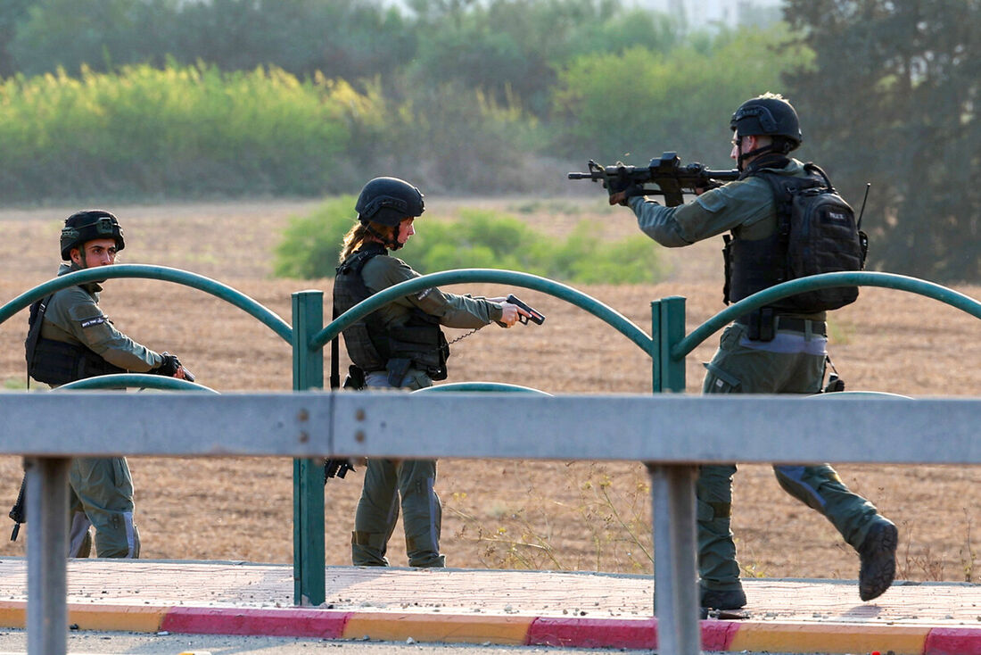 Membros das forças de segurança israelenses protegem área perto de posto de controle