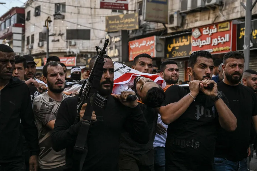 Palestinos carregam o corpo de um homem morto durante uma confrontos com o exército israelense no campo de refugiados de Jenin