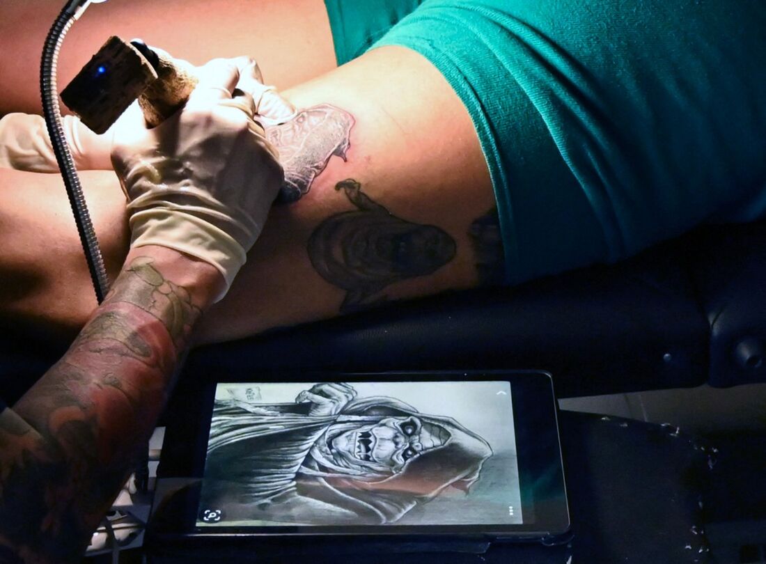 Tatuador realiza uma tatuagem em seu estúdio em Guayaquil, província de Guayas