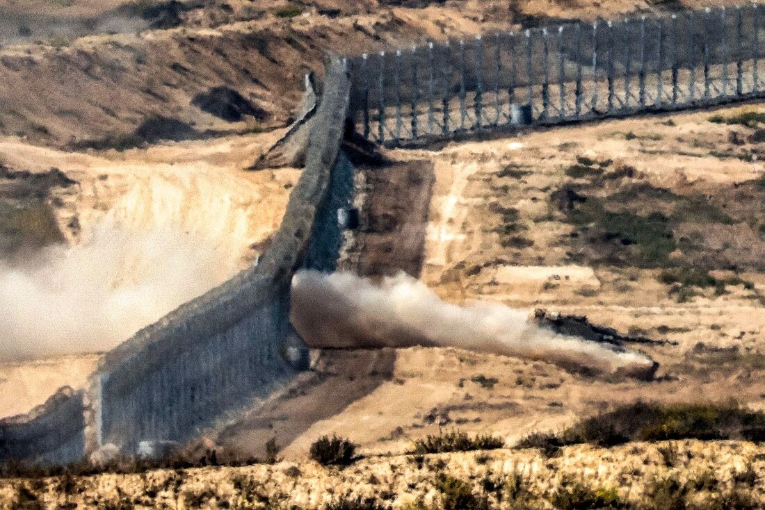 Tanque de guerra do exército israelense atravessa uma cerca de arame farpado em uma posição ao longo da fronteira com a Faixa de Gaza 