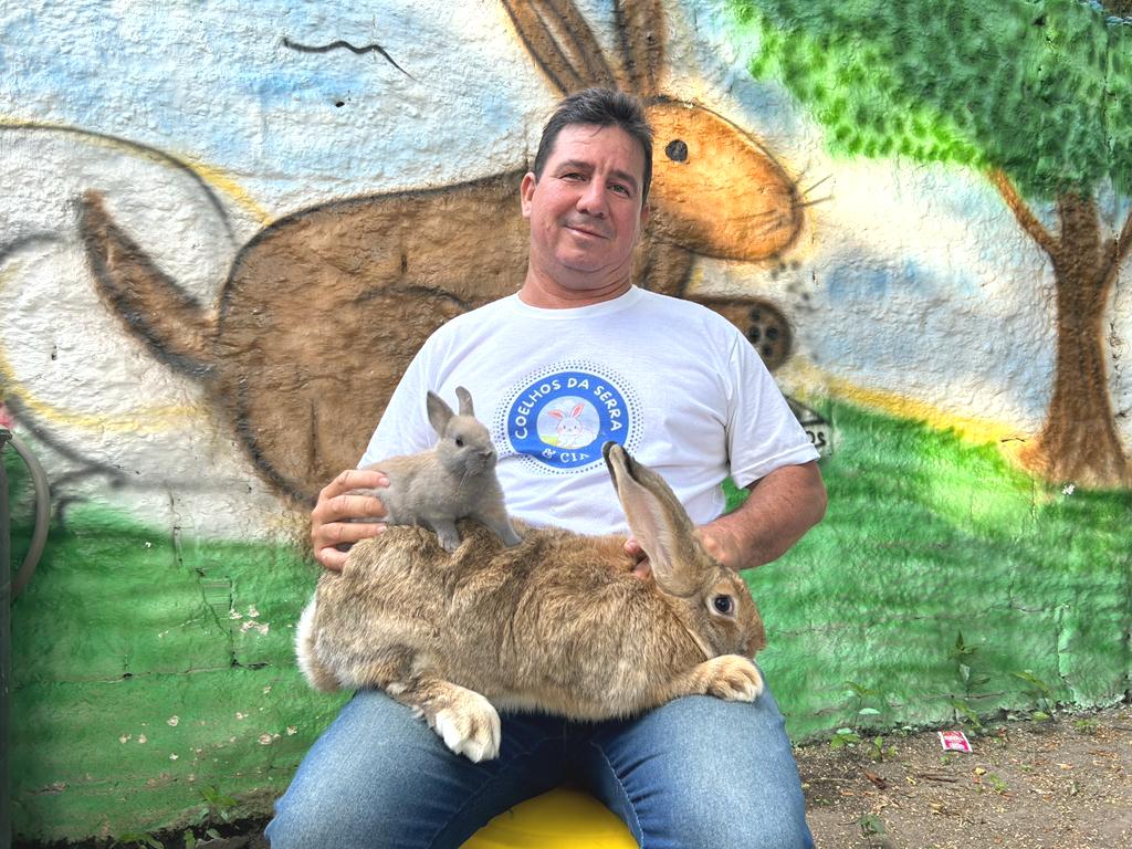 Araken com um exemplar da maior raça de coelho do mundo (Gigante de Flandres) e a menor (Netherland Dwarf), que ele cria
