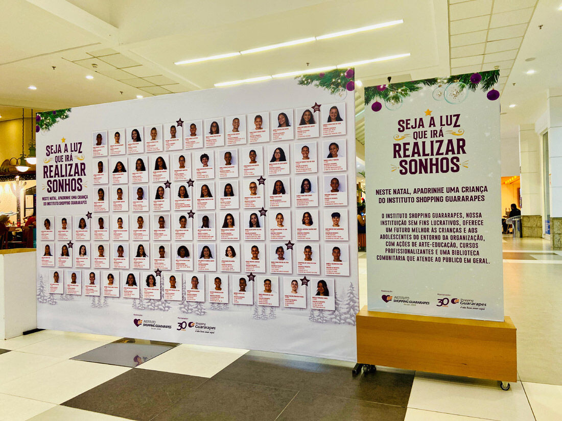 Painel no corredor do cinema apresenta fotos de crianças carentes que serão beneficiadas pela ação