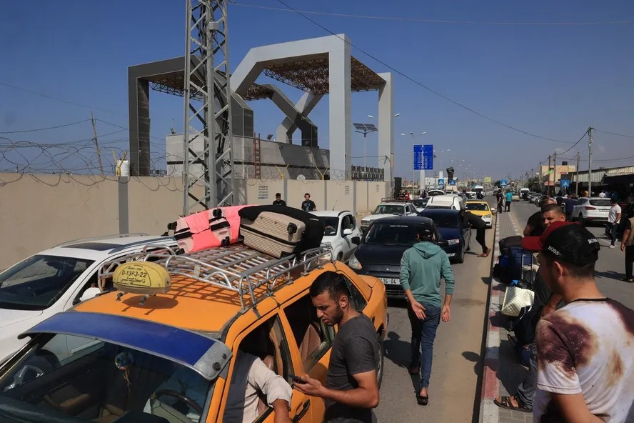 Palestinos com passaportes estrangeiros tentam atravessar a fronteira para entrar no Egito, a mesma travessia que querem realizar os brasileiros  Foto: 