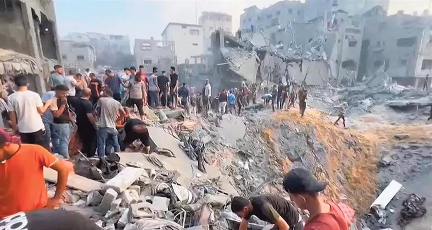 Terra arrasada. Palestinos se reúnem junto a uma enorme cratera no campo de refugiados de Jabaliya, no norte da Faixa de Gaza, após um ataque israelense que deixou dezenas de mortos