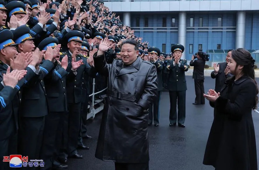 Kim Jong Un e sua filha reunidos com cientistas que contribuíram para o lançamento de um satélite de reconhecimento