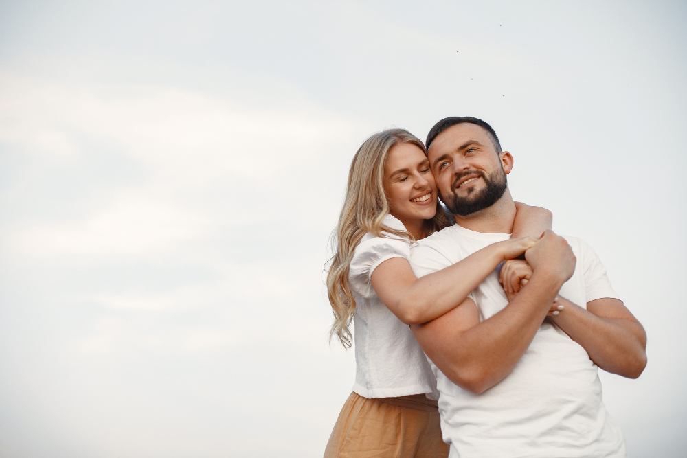 Casal  em um campo. senhora em uma blusa branca. cara em uma camisa branca