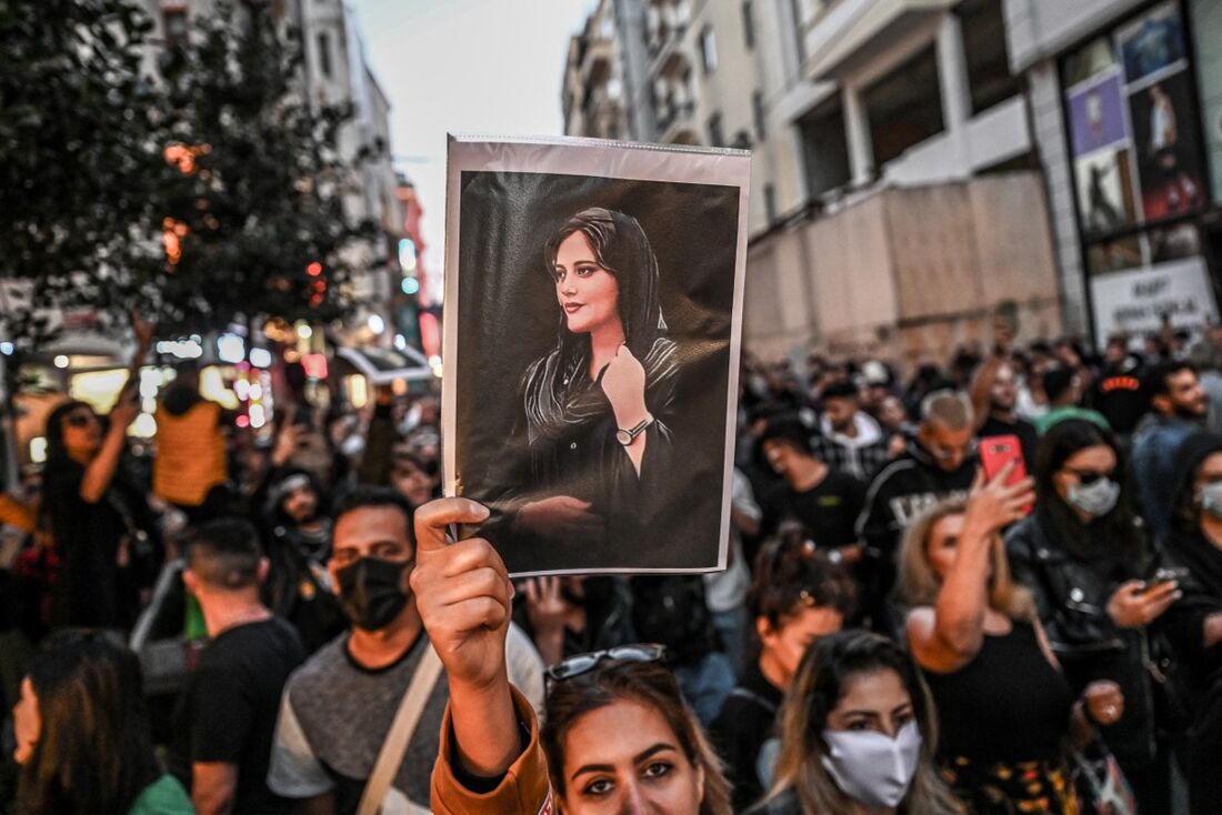  Manifestante segura um retrato de Mahsa Amini durante uma manifestação em apoio a Amini, uma jovem iraniana que morreu após ser presa em Teerã pela polícia moral da República Islâmica