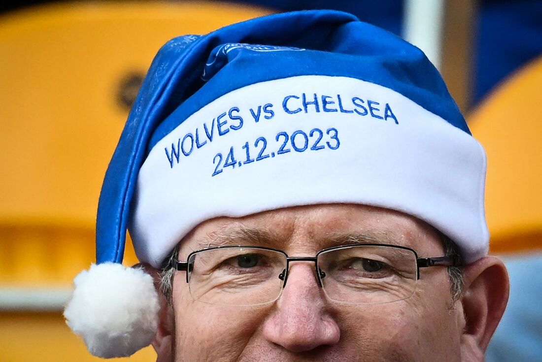 Torcedor do Chelsea usa gorro de Papai Noel personalizado indicando jogo na véspera de Natal