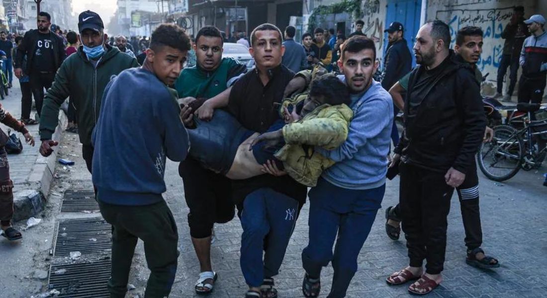 Palestinos carregam homem ferido em bombardeio israelense em Rafah, no sul de Gaza