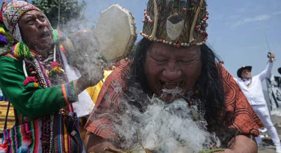 Xamãs peruanos, equipados com folhas de coca, espadas, potes de cerâmica fumegantes e incenso, executam um ritual para fazer suas previsões para o próximo ano no topo de uma colina em Lima