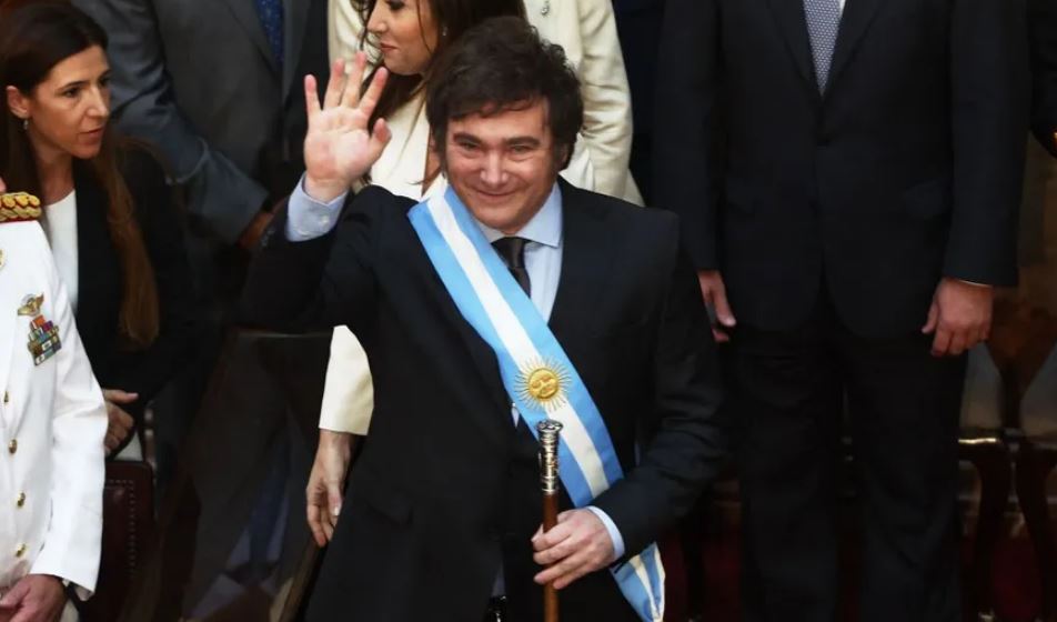 Javier Milei acena depois de receber a faixa e o bastão presidencial durante sua cerimônia de posse no Congresso em Buenos Aires