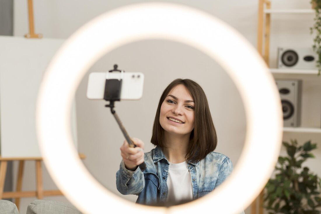 Mulher usa ring light e celular para gravar vídeo