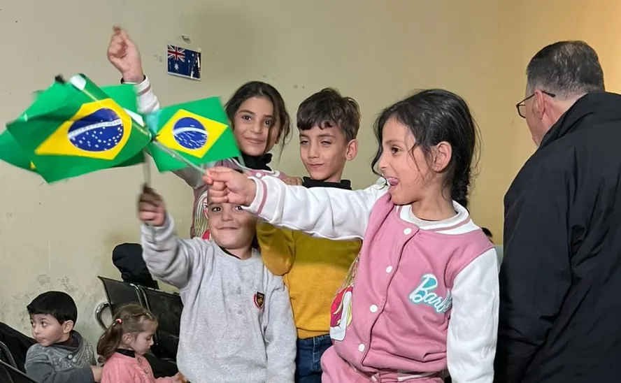 Crianças retiradas da Faixa de Gaza brincam com bandeiras do Brasil 