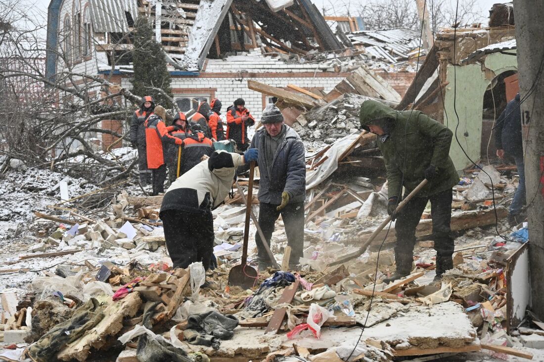 Equipes de resgate e residentes locais removem destroços após ataques russos, em Zmiiv 