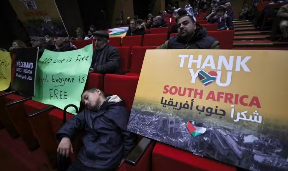 Palestinos assistem à transmissão ao vivo da audiência na CIJ sobre caso movido pela África do Sul contra Israel em Ramallah, na Cisjordânia ocupada 