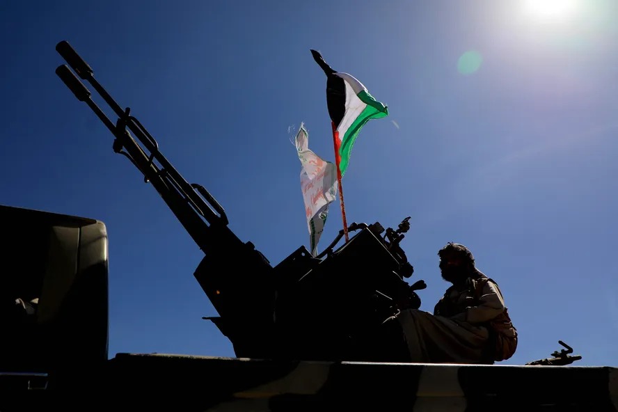 Combatente houthi em veículo com bandeira da Palestina durante protesto contra Israel 